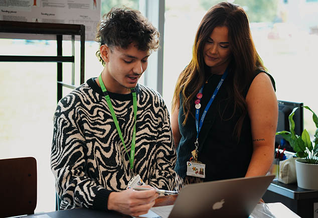 Teacher standing next to students