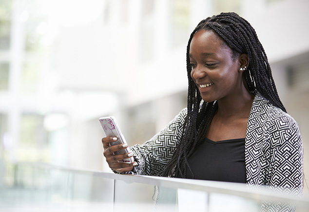 Student smiling whilst looking at phone