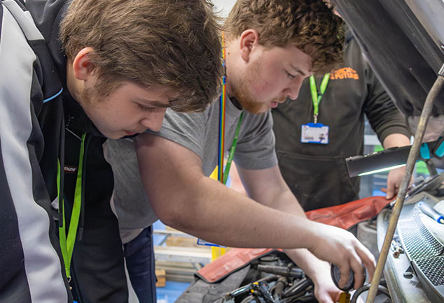 Students looking under car bonnet
