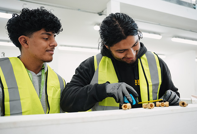 Students working on plumbing pipes