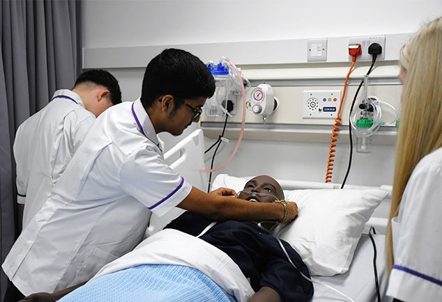 Mock hospital ward with beds and mannequins 