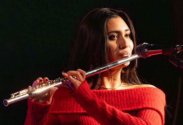 Female student playing musical instrument with mic in front of her