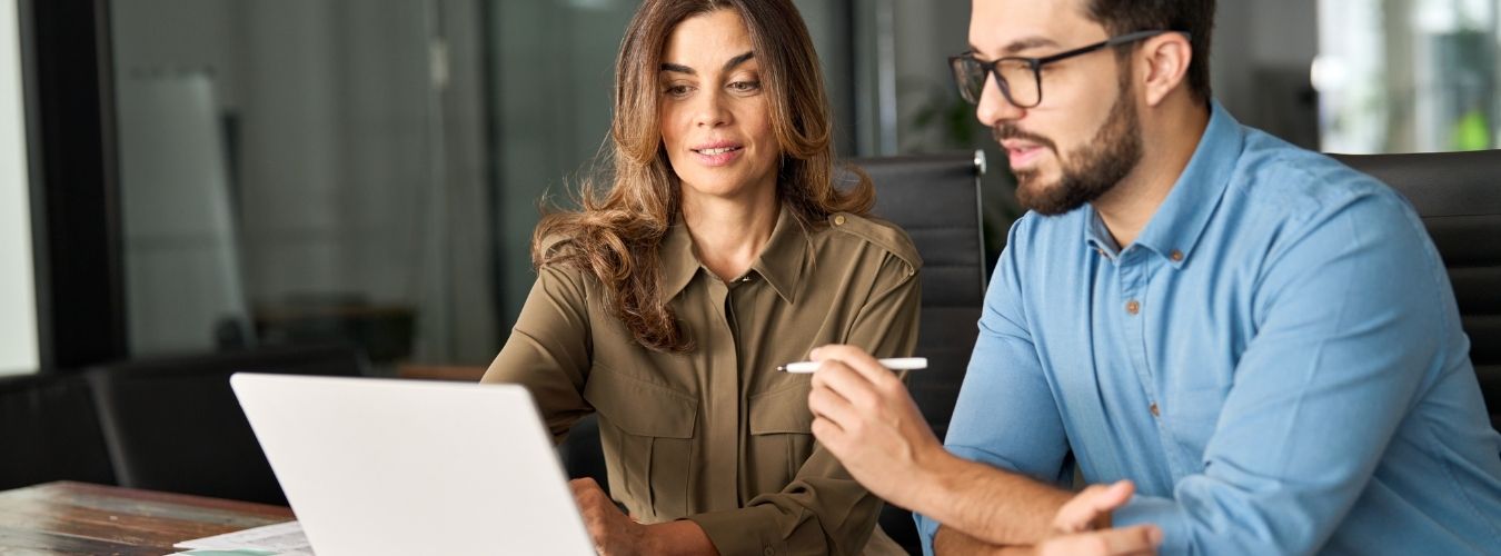 Two adults sitting together looking at laptop screen