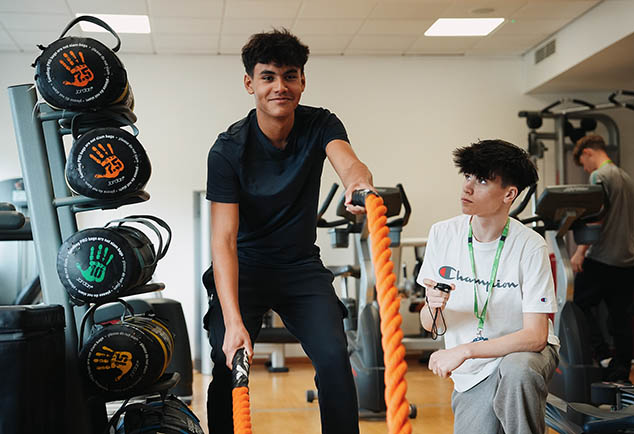 Student using rope equipment in gym