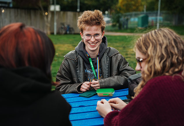 Student sitting outside on a bench talking