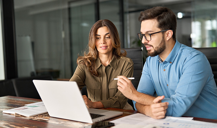 Two adults looking at laptop screen