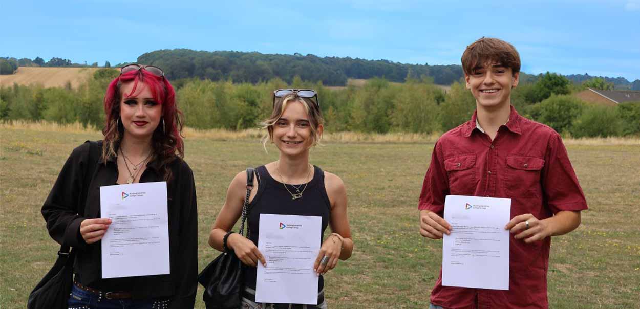 Students holding exam results and smiling 